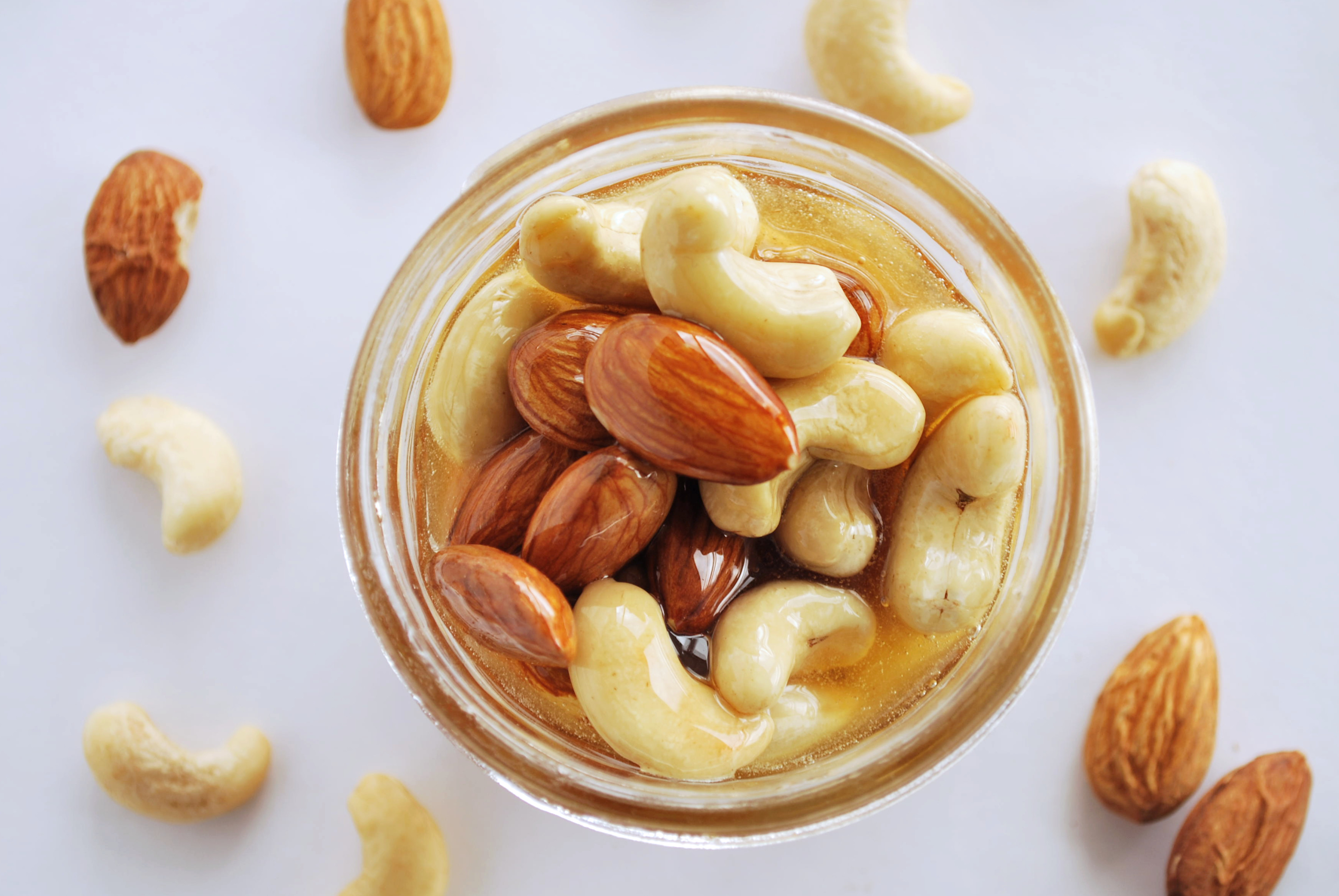 Healthy Mix Of Natural Honey With Different Nuts In A Jar On Blue
