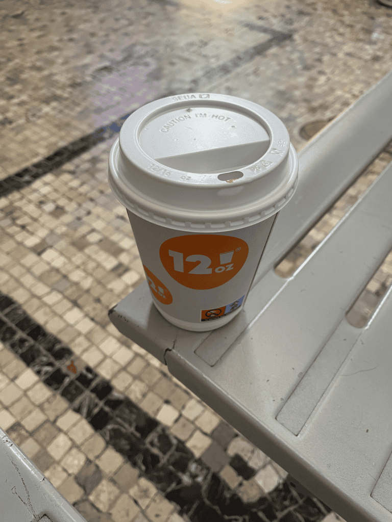 a travel coffee cup with the 12oz logo on it