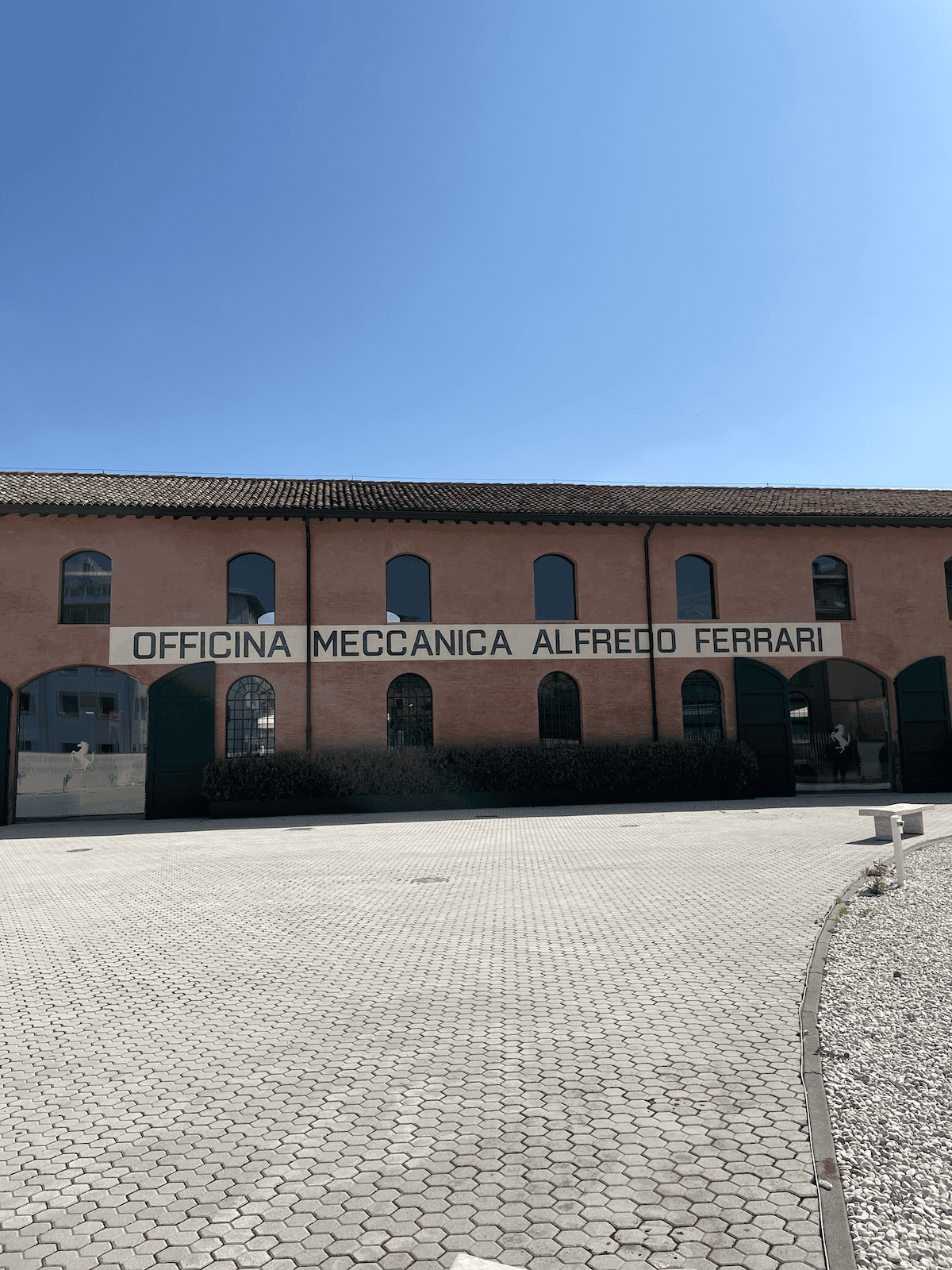 a brick wall that says 'Officina meccanica Alfredo Ferrari'