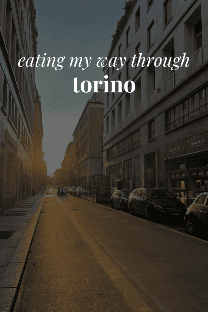 a Torino street with the sun peaking through and the words 'eating my way through torino' on top