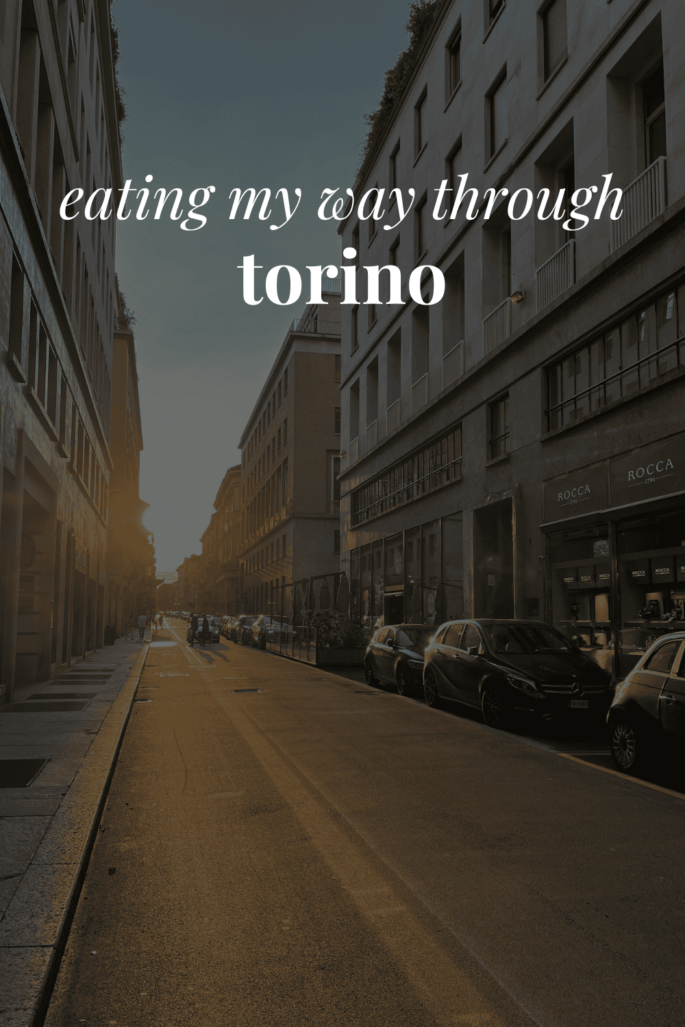 a Torino street with the sun peaking through and the words 'eating my way through torino' on top