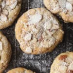 a close up of sugar cookies with almonds and powdered sugar on top