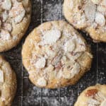 a close up of sugar cookies with almonds and powdered sugar on top