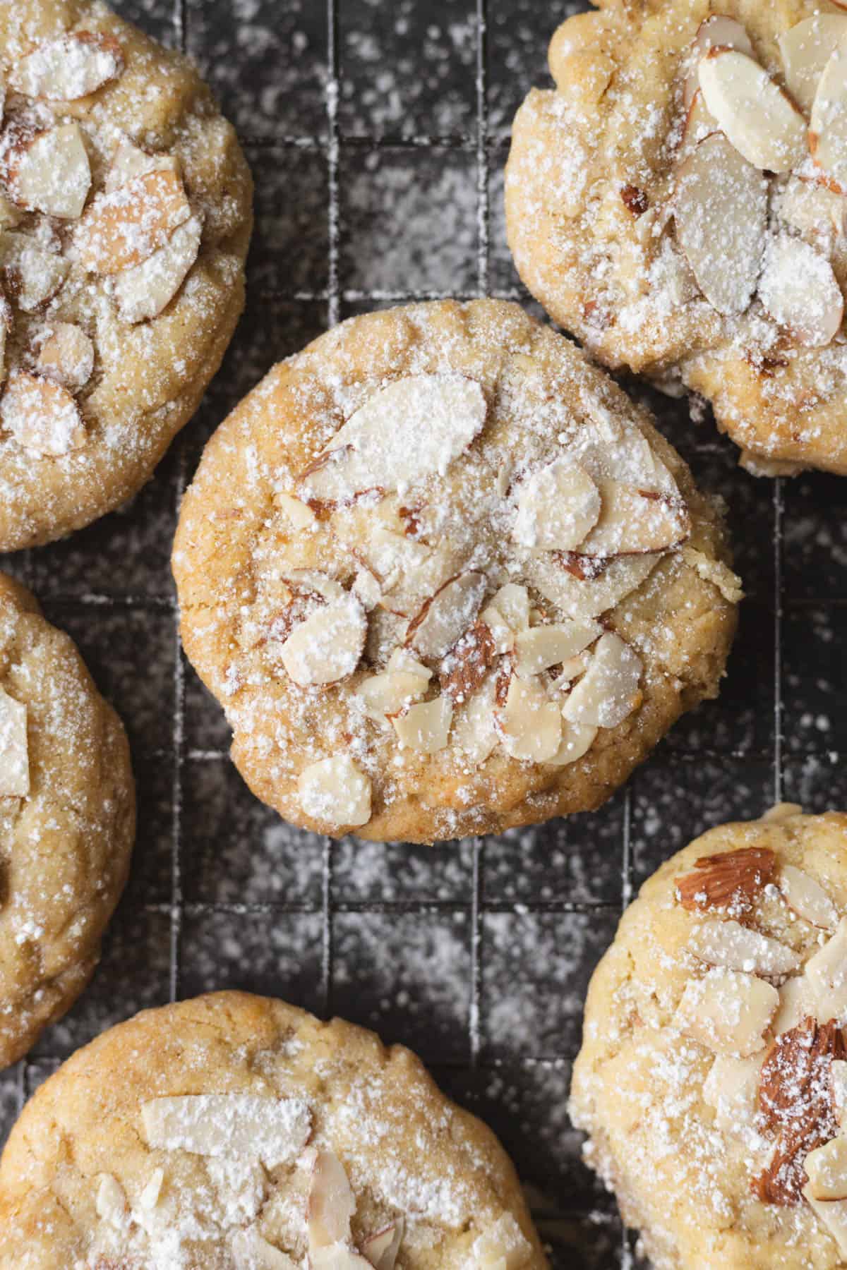 a close up of sugar cookies with almonds and powdered sugar on top