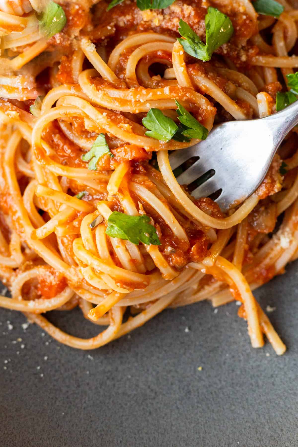 a fork twirling in pasta covered in a vegan/vegetarian mushroom bolognese