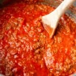 A pot of vegan/vegetarian mushroom bolognese with a wooden spoon